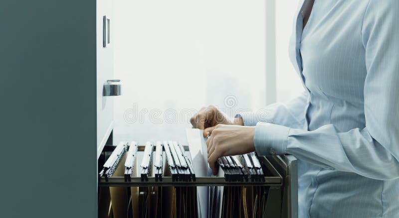 Professional Female Office Clerk Searching Files And Paperwork In The